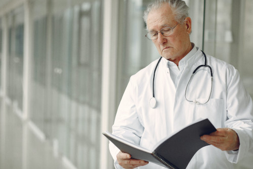 Doctor standing in a hallway reading a patient sheet